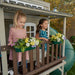 Kids playing at the balcony of the wooden playhouse