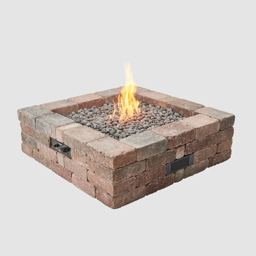  Closeup of the Outdoor Greatroom Co Bronson Block Gas Fire Pit Kit Square with flames, focusing on the pit's texture and fire media, SKU BRON5151-K.