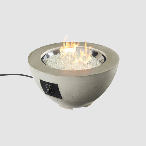 A close-up of the Outdoor Greatroom Co Cove Round 29-inch gas fire pit bowl with flames reflecting on glass gems.
