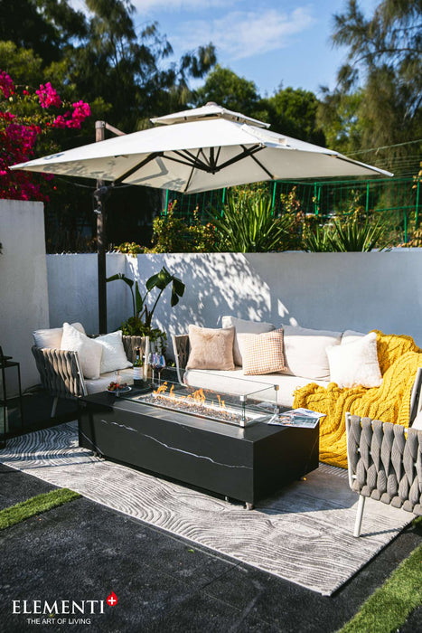 Outdoor patio showcasing a Bulgaria Black Varna Marble Porcelain Fire Table, complemented by a table and chairs