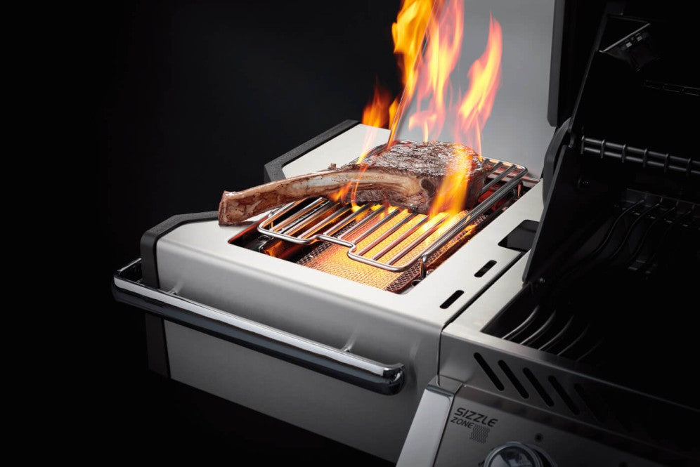 Close-up of a sizzling steak on the Napoleon Grills Prestige PRO™ 500 RSIB's infrared side burner, showcasing the intense heat and grilling power.