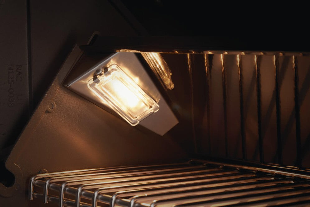 Illuminated interior of the Napoleon Grills Prestige PRO™ 500 RSIB showing the internal lights that enhance visibility for nighttime grilling.