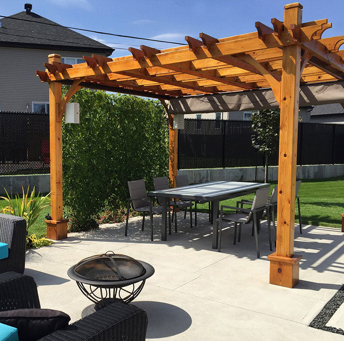 Outdoor Living Today Pergola with Retractable Canopy 12x12 providing shade to an outdoor dining set placed on a leveled cement floor