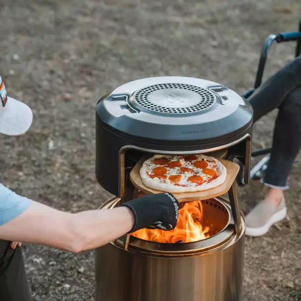 Solo Stove Fire Pit Pizza Oven Pi Fire with person pizza inside.