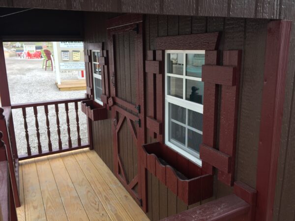 The inviting porch and space of the Craftsman Playhouse with Slide by Little Cottage Company, perfect for relaxing and enjoying the surrounding scenery