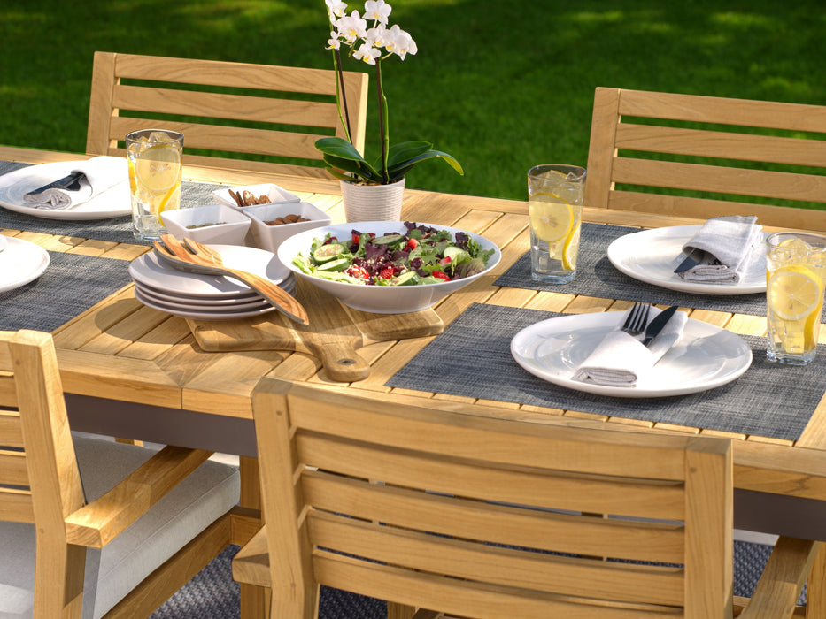 Rhodes dining set under sunlight with a fresh meal set up, including lemonade and a salad on a placemat.