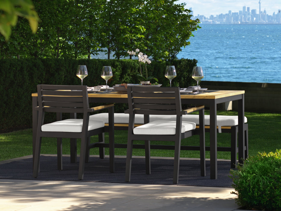 Rhodes 4-seater dining set with 72-inch table overlooking a waterfront, set for a meal with wine glasses.