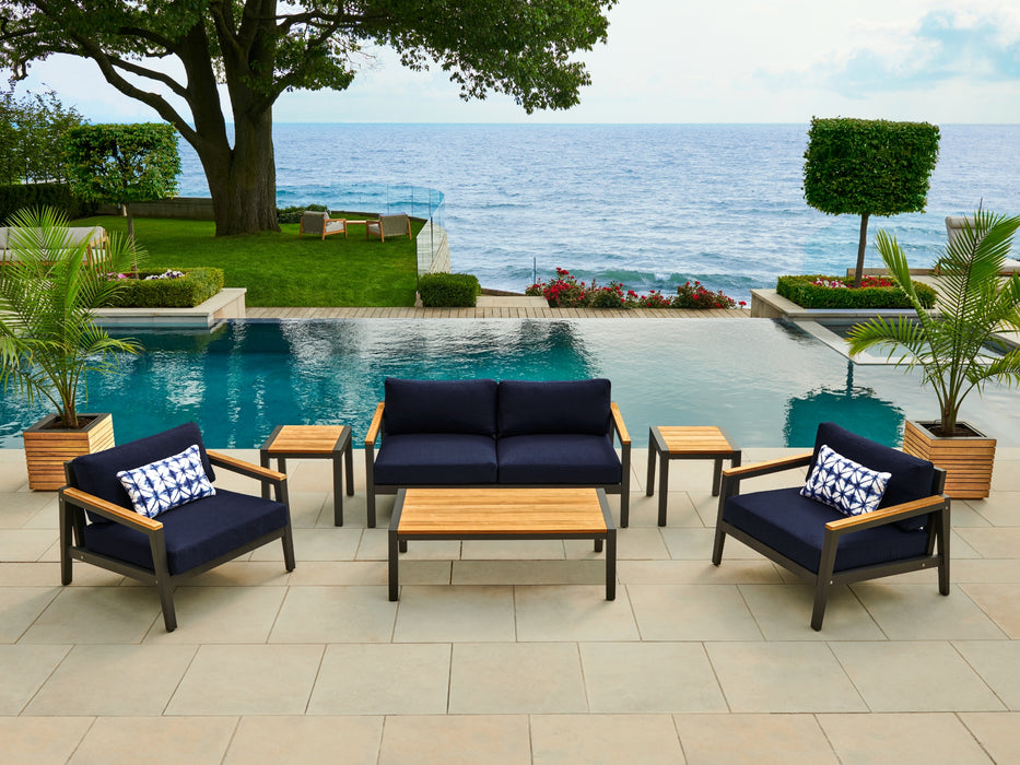 Rhodes Furniture Set with blue cushions and patterned pillows, part of an outdoor seating arrangement.