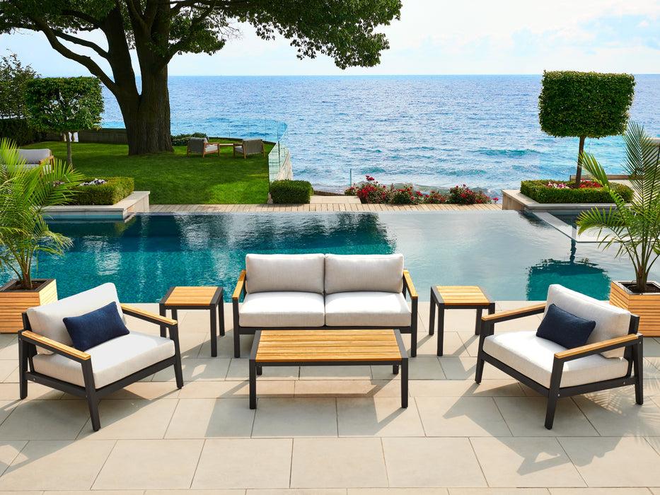 Rhodes Furniture Set with Canvas Natural cushions placed poolside with ocean view.