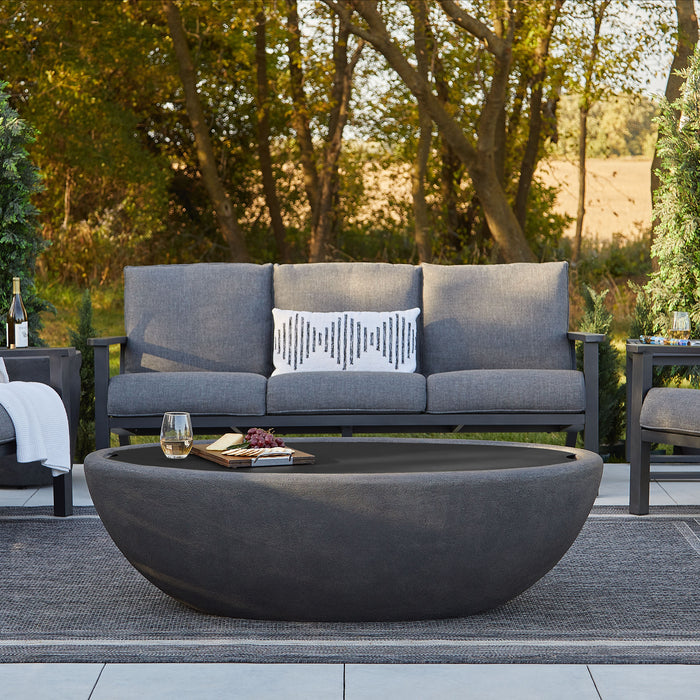 Riverside Fire Bowl's Large Oval Steel Lid set in an outdoor lounge setting-Lifestyle in the patio with two chairs and a couch