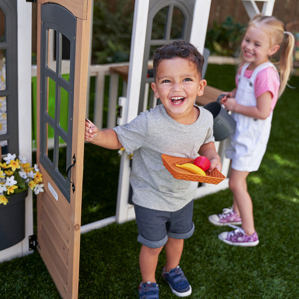 A boy enjoying the white playhouse for kids