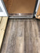 EzFit wooden ramp with diamond-patterned metal trim for seamless shed entry on laminate flooring.