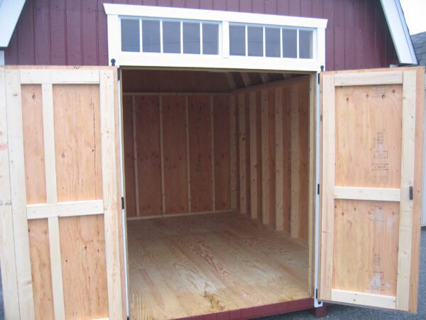 Inside the Colonial Woodbury shed showing the unfinished wood walls and floors, ready for personal customization.