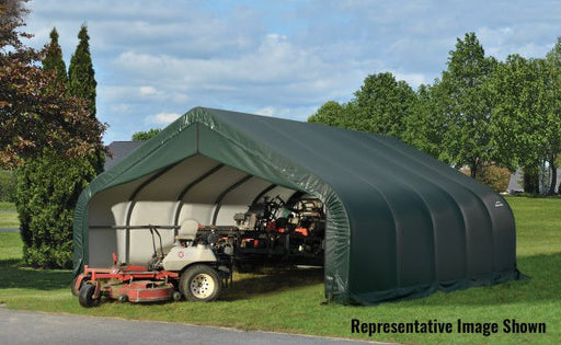 ShelterLogic ShelterCoat 18 x 28 ft. Garage Peak green with a small tractor parked inside it. There are trees in the backyard.