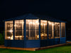 Image of the Freestanding Solarium gazebo with a slate metal roof installed in a backyard setting at night