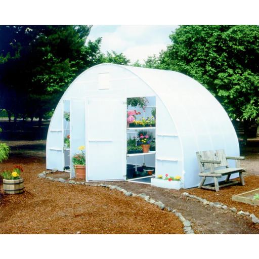 Exterior view of a white Solexx Conservatory Deluxe model measuring 16 by 20 feet with translucent walls, showcasing potted flowers and a rustic bench outside