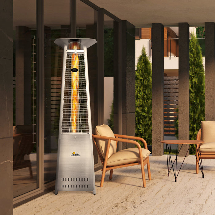 An elegant Stainless steel Vesta Heater is placed on a patio next to stylish outdoor furniture, enhancing the ambiance of a modern outdoor living space.