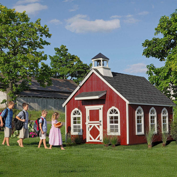 Children happily entering the Little Cottage Company Stratford Schoolhouse Playhouse in a lush garden setting.