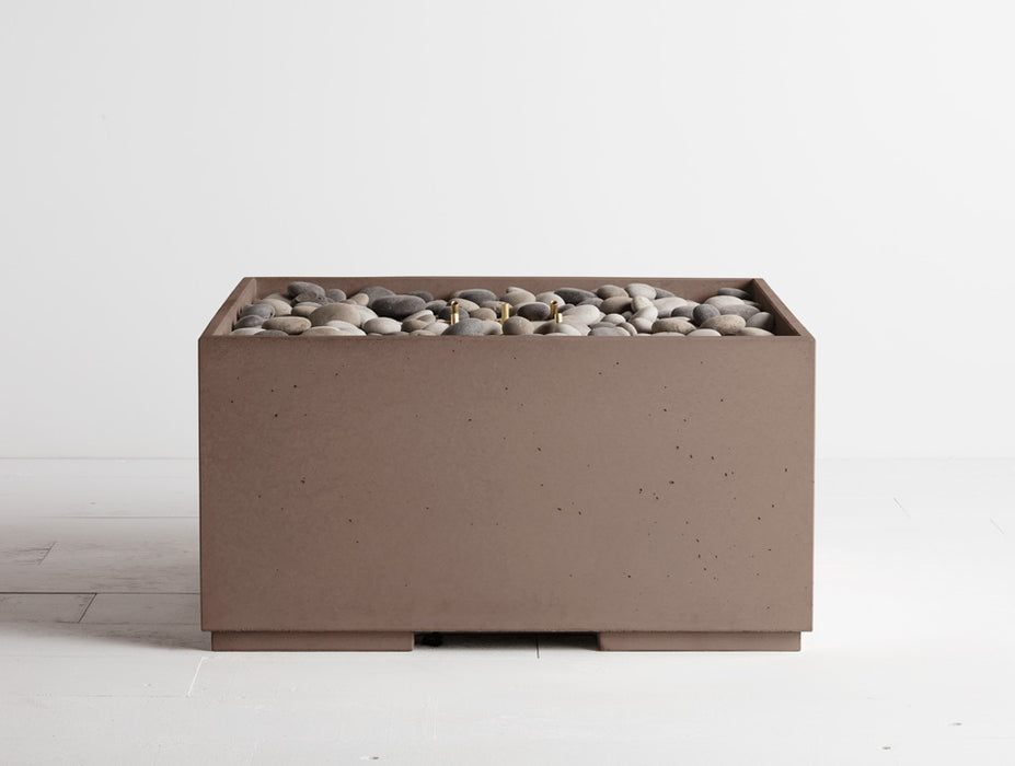 Truffle brown Solus Decor Firebox 30, presenting a robust cubic structure filled with contrasting grey stones for a stylish outdoor gathering point.