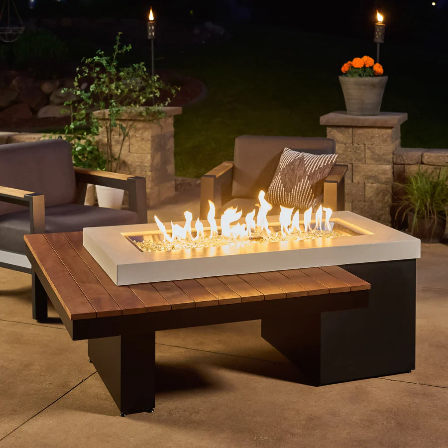 The Fire Pit Table in operation during the evening, with visible flames and nearby outdoor furniture.