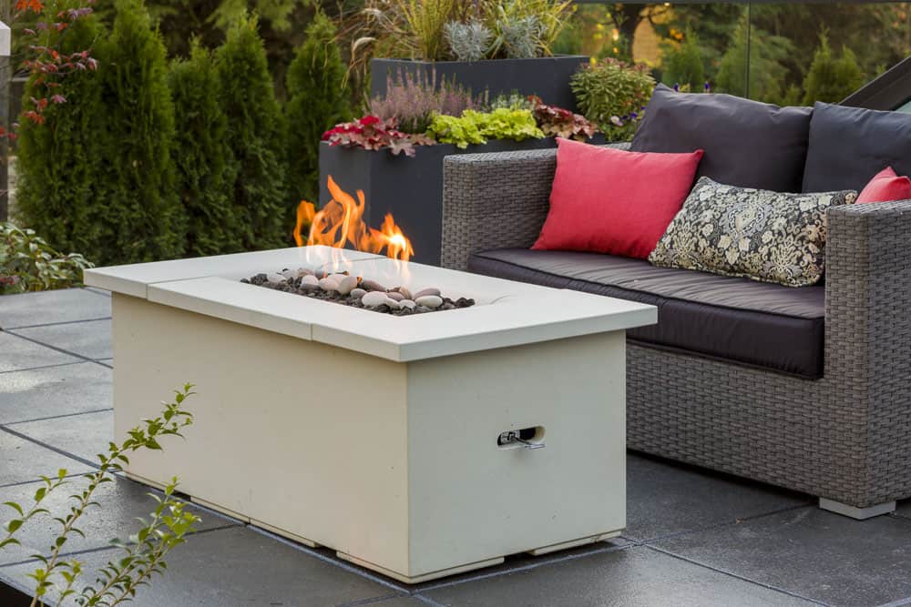 Solus Halva Firetable set in a lush urban garden, offering a warm flame for cozy conversations on cool evenings.