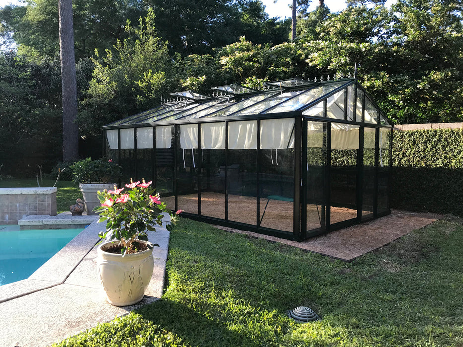 A serene poolside view featuring the Exaco Janssens Royal Victorian VI 46 Greenhouse with an open door, inviting a look inside at the flourishing plant life.