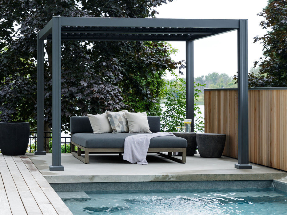 Showing the Vikos Aluminum Stand Alone Pergola in a different setting on a deck, but this time overlooking a pool. It is positioned to provide a sheltered lounging area, demonstrating the pergola's versatility in various outdoor environments.