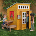 Three kids playing on the outdoor playhouse