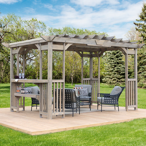 Fully assembled 10 x 14 Cedar Pergola in a garden setting with outdoor furniture under its shelter.