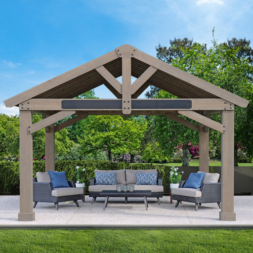 Fully assembled Yardistry 16x14 Pavilion in a garden setting with outdoor furniture under its shelter.
