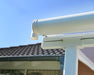 Side view of adjustable gutters on Canopia Sierra Patio Cover - White/Clear, illustrating the water drainage system.