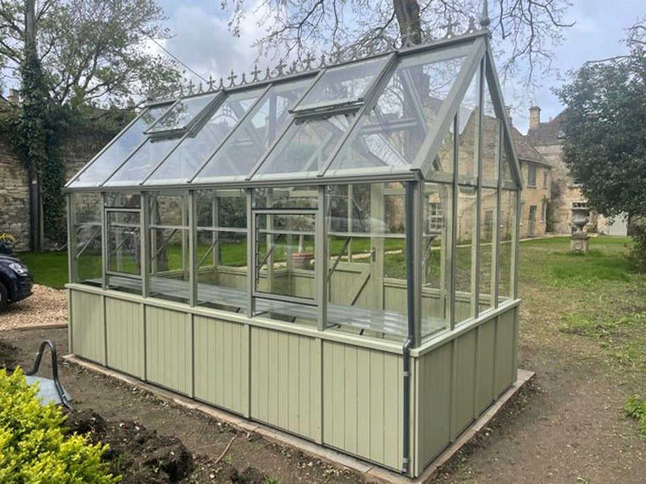 A frontal view of the Alton Cedar Structure Durham Greenhouse, showcasing its solid cedar framework and sleek lines.