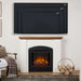 Real Flame Anika white electric fireplace with black surround in living room beneath wall-mounted TV showing 50", 60", and 70" size comparisons, with log basket and armchair