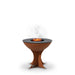 A round Arteflame grill with a tall Euro base stand, featuring a wood fire burning on its black cooking surface, emitting smoke.