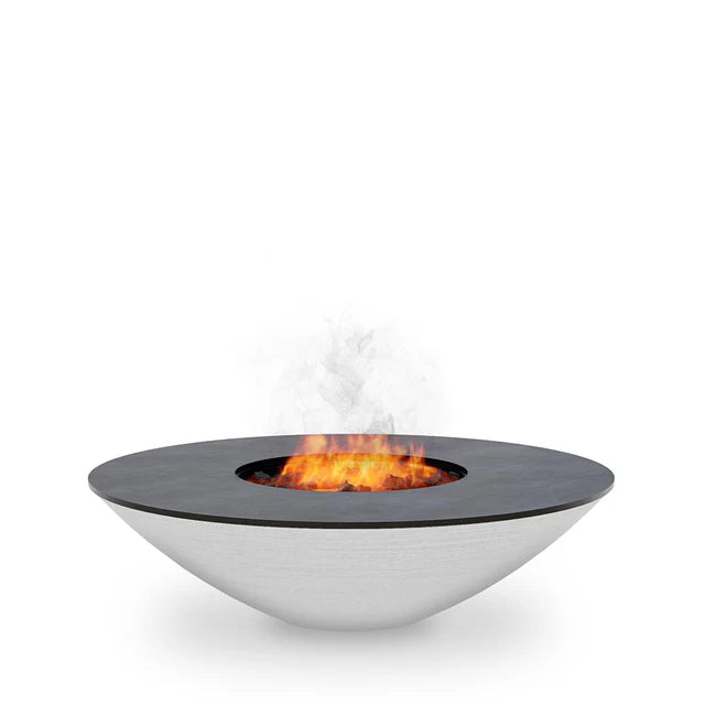 The Arteflame 40" Platinum Series Fire Pit With Cooktop is a sleek, modern fire pit featuring a wide, circular metal base and a black top, with visible flames and smoke emanating from it.