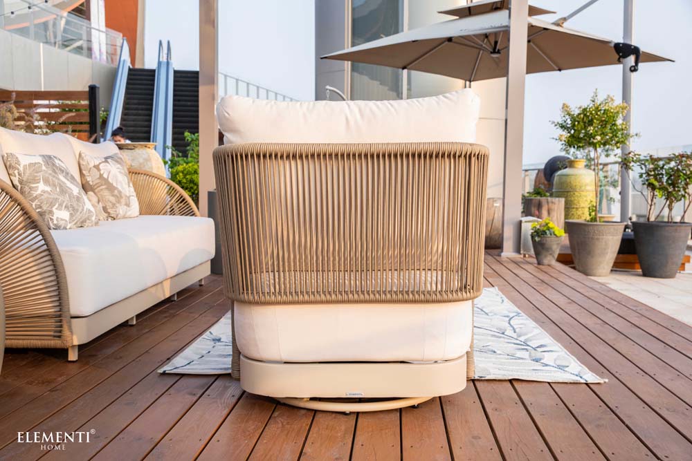 Rear view of Malibu Collection lounge chair by Elementi, showcasing the circular woven rope back design and durable outdoor cushion on wood decking.

