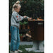 A young child attentively grilling a variety of vegetables on the Arteflame One 20 Black Label Grill, emphasizing the grill's user-friendly design and family-oriented appeal.