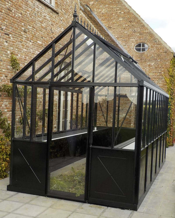 Side gable view of a black Exaco Janssens Retro Royal Victorian Greenhouse with X-pattern base panels, tall glass walls, and decorative roof cresting.