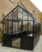 Side gable view of a black Exaco Janssens Retro Royal Victorian Greenhouse with X-pattern base panels, tall glass walls, and decorative roof cresting.