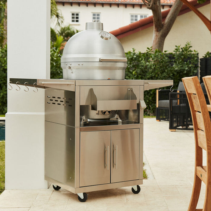 Blaze Grills 20-inch Kamado Grill in a modern outdoor setting, showcasing its sleek stainless steel design with storage cabinets, hooks for tools, and a stylish patio backdrop