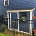 Charming blue SpaceSaver 8x4 storage shed with a single door, conveniently placed beside a residential house for easy access.