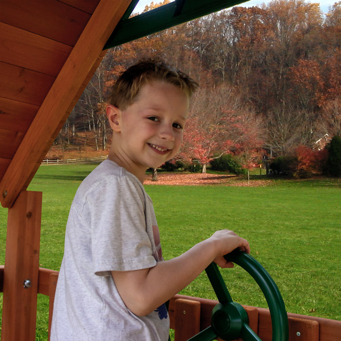 A child playing the steering wheel of the wooden Frontier Swing Set