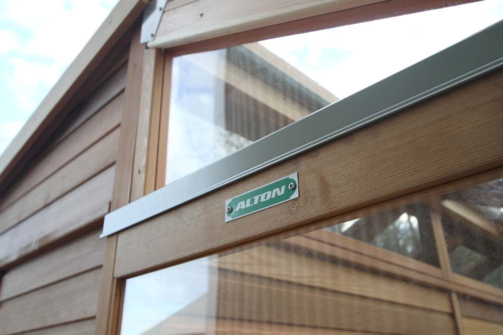 Close-up of the Alton logo on the wooden frame of the greenhouse, highlighting the detailed craftsmanship.