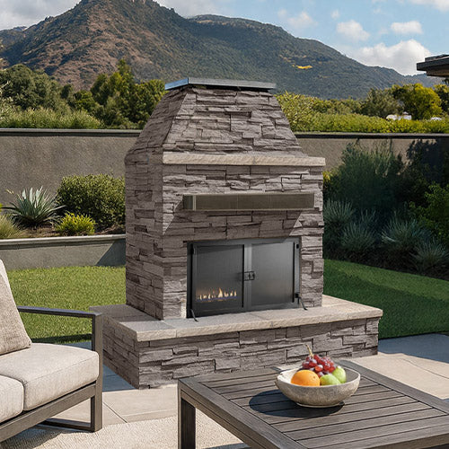 Cal Flame Platinum Key West outdoor fireplace installed in a landscaped patio with stone and brick finish.