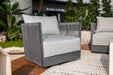 Elementi Capri Collection swivel chair displayed on a contemporary patio, featuring a sleek gray frame and soft gray cushions in lush garden setting.