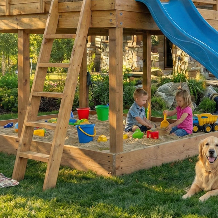 Close-up of children playing in the sandbox beneath the Cozy Cabin Playhouse, with the blue slide and family dog