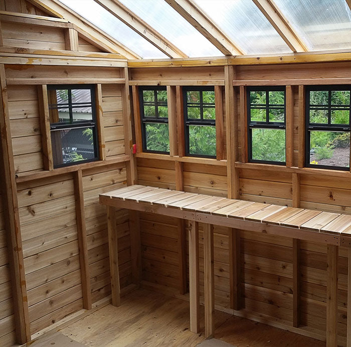 Interior view of the cedar walls and spacious work area inside the Outdoor Living Today 8x8 Sunshed Garden Shed with natural light filtering through clear roofing