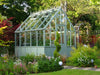 Alton Cedar Structure Cheltenham Victorian Greenhouse surrounded by a garden in full bloom.