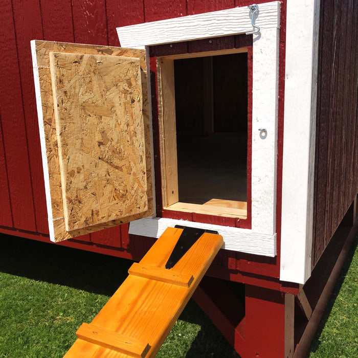 Close-up of the chicken coop ramp and door design from Little Cottage Co., showing wood construction and secure latch.