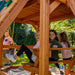 Girls on the picnic table of the wooden Great Skye II Swing Set